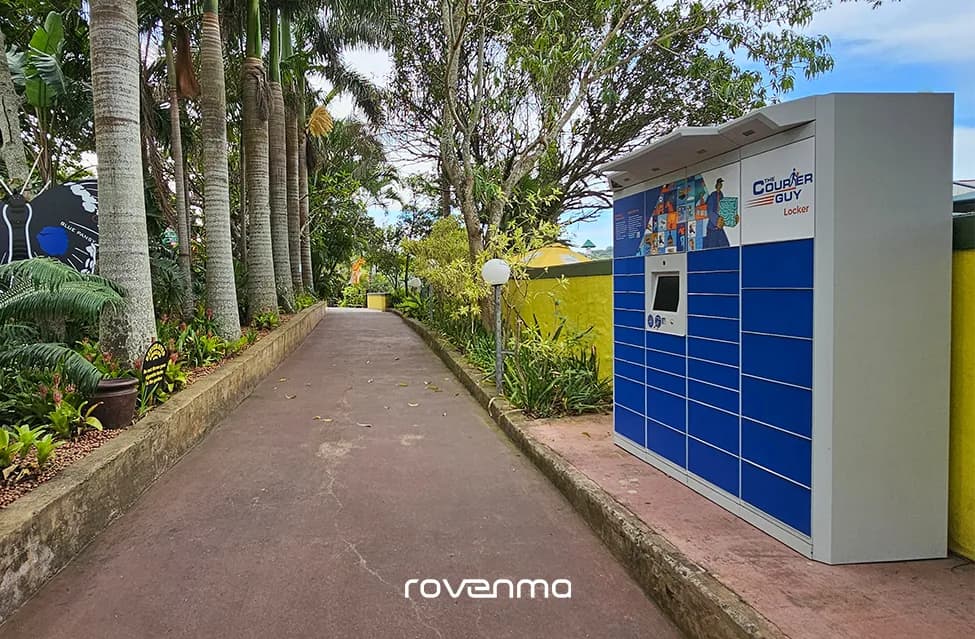 A Courier Guy locker at the end of a path under palm trees